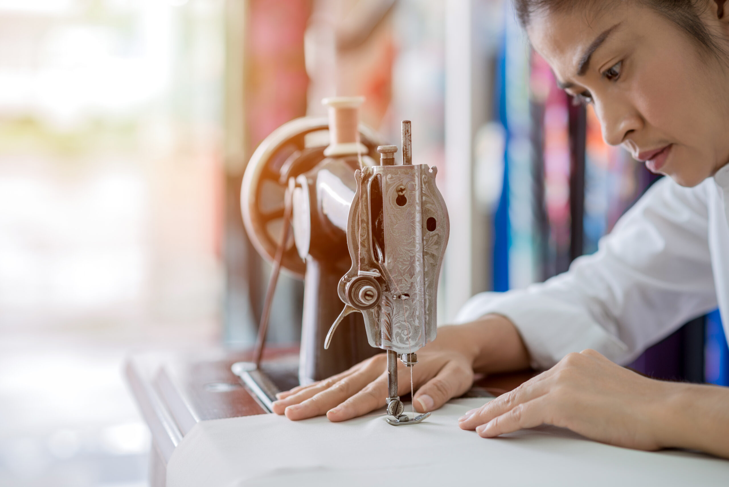 woman is sewing with sewing machine at home